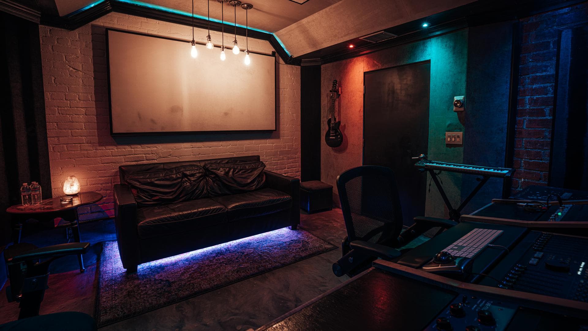 Exposed brick wall washed in red and teal light inside The Brick Room at Weddington Studios in North Hollywood