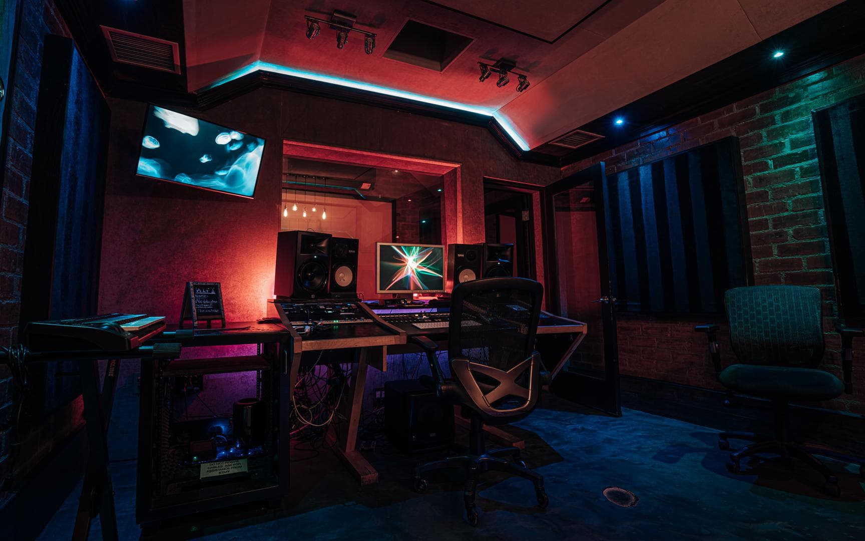 Wide view of the Brick Room with the desk, lounge, and cove lighting